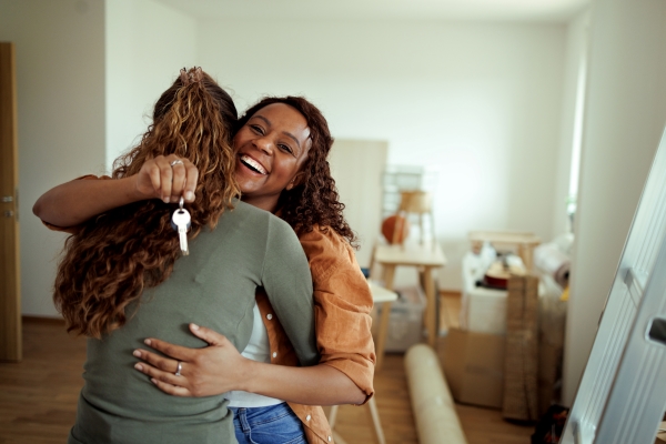 two young women hugging in their new home